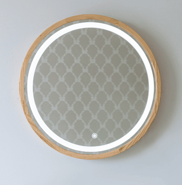 Pitagoras-Perfection-Slim-LED.png to okrągłe lustro z drewnianą ramą i podświetlanym pierścieniem LED, odbijającym tapetę w geometryczne wzory. W dolnej środkowej części znajduje się przycisk z czujnikiem dotykowym.